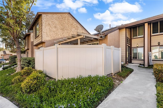 view of side of home with fence and stucco siding