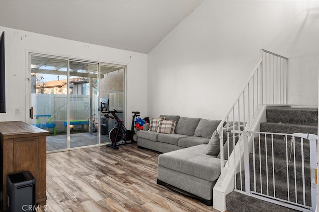 living room featuring stairs, high vaulted ceiling, and wood finished floors