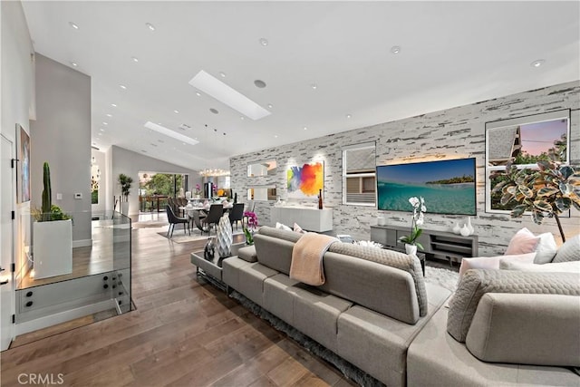 living area featuring high vaulted ceiling, a skylight, wood finished floors, and recessed lighting