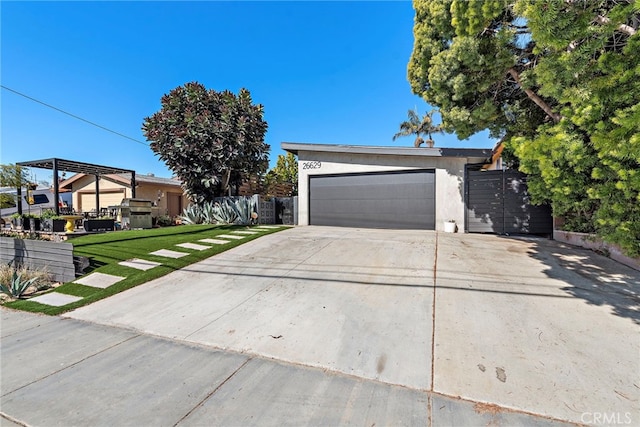 view of front of property with stucco siding, a gate, fence, a garage, and driveway