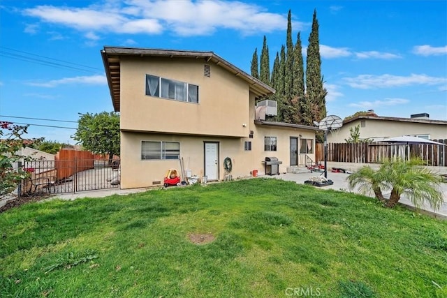 back of property featuring a patio area, stucco siding, fence private yard, and a lawn