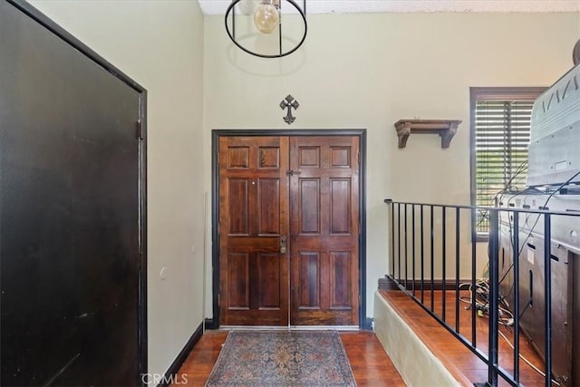 entryway featuring baseboards and dark wood finished floors