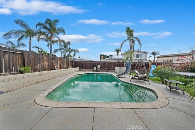 view of swimming pool featuring a fenced in pool, a patio, a water slide, and a fenced backyard