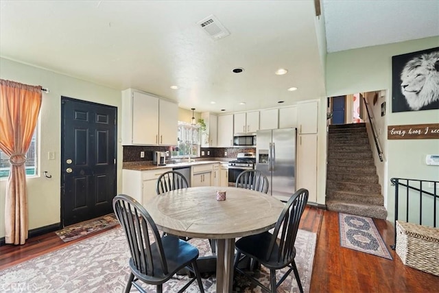 dining room featuring visible vents, recessed lighting, stairway, and wood finished floors