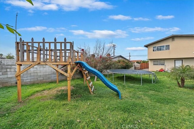 view of playground featuring a lawn and a trampoline