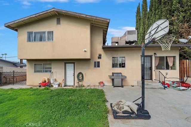 back of house with stucco siding, a patio, and fence