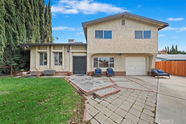 back of property featuring fence, driveway, stucco siding, a garage, and a lawn