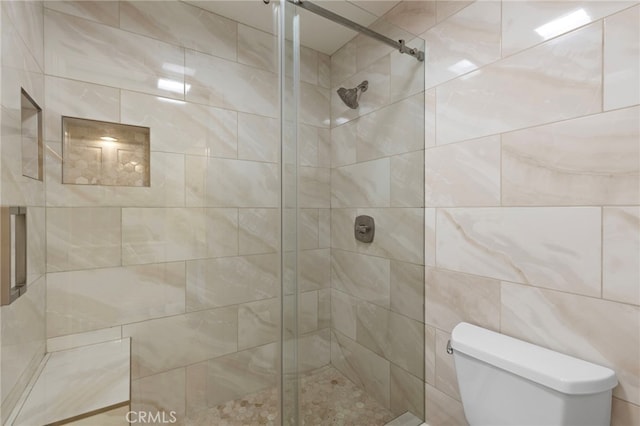 bathroom featuring a stall shower and toilet