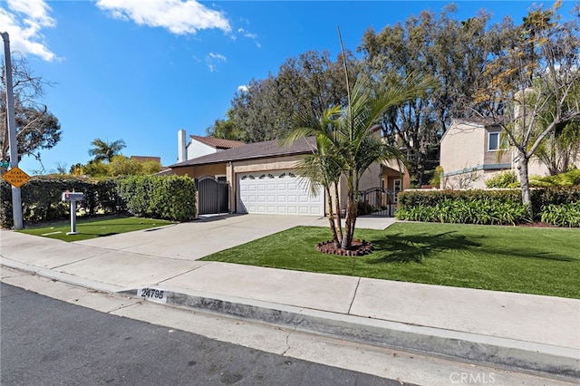 view of front of property with a garage, concrete driveway, a gate, fence, and a front yard