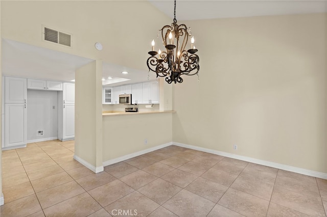 interior space featuring lofted ceiling, light tile patterned flooring, visible vents, and baseboards