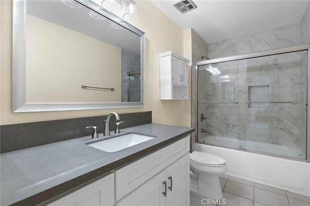 full bathroom featuring visible vents, toilet, tile patterned floors, combined bath / shower with glass door, and vanity