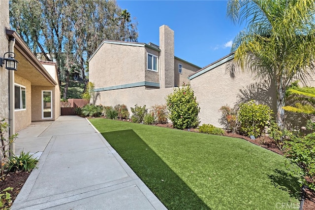 view of yard with fence and a patio