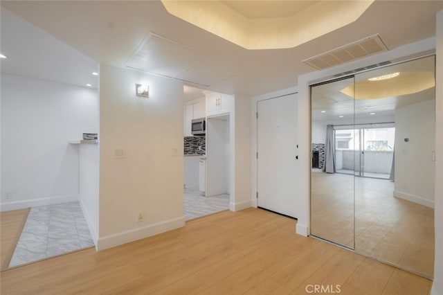 unfurnished room with baseboards, visible vents, and light wood-style floors