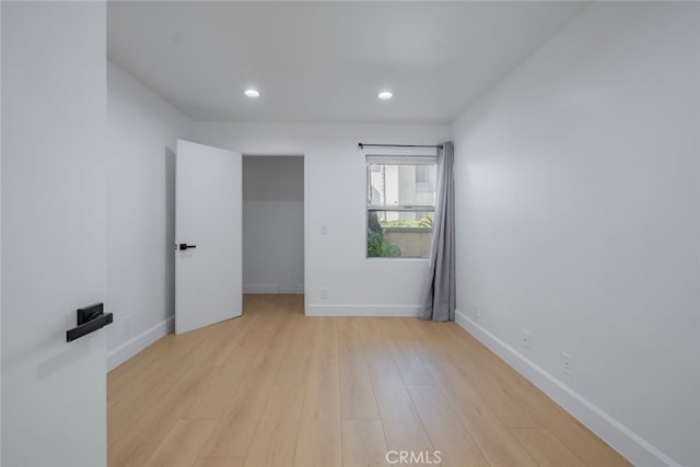 empty room with recessed lighting, light wood-style flooring, and baseboards