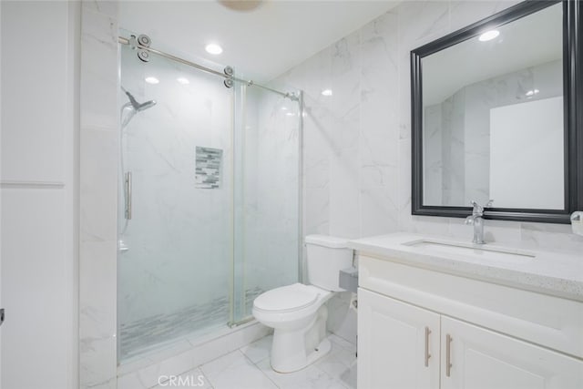 full bath with a marble finish shower, toilet, marble finish floor, vanity, and tile walls