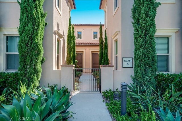 exterior space with a gate and stucco siding