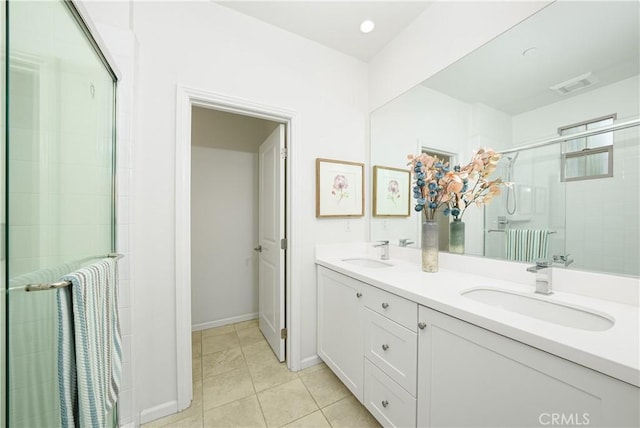 full bath with double vanity, a stall shower, tile patterned flooring, and a sink