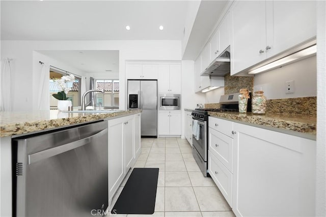 kitchen featuring white cabinets, under cabinet range hood, stainless steel appliances, and a sink