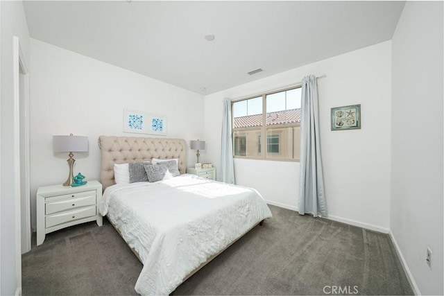 bedroom featuring dark colored carpet, visible vents, and baseboards