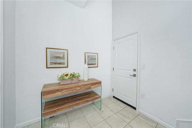 foyer featuring light tile patterned floors and baseboards