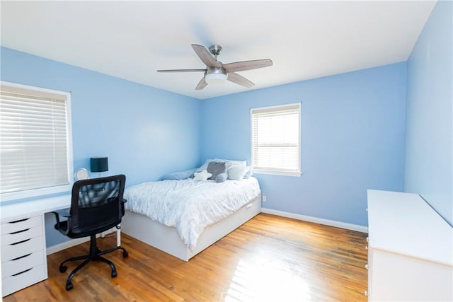 bedroom with ceiling fan, baseboards, and wood finished floors