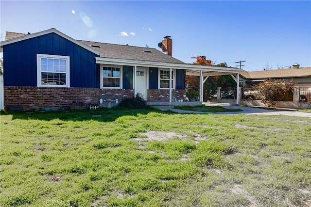 ranch-style home featuring brick siding, a chimney, board and batten siding, and a front yard