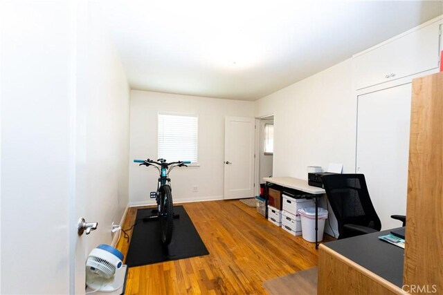 workout room with wood finished floors and baseboards