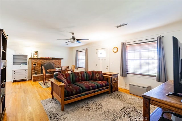 living room featuring light wood-style floors, plenty of natural light, and visible vents