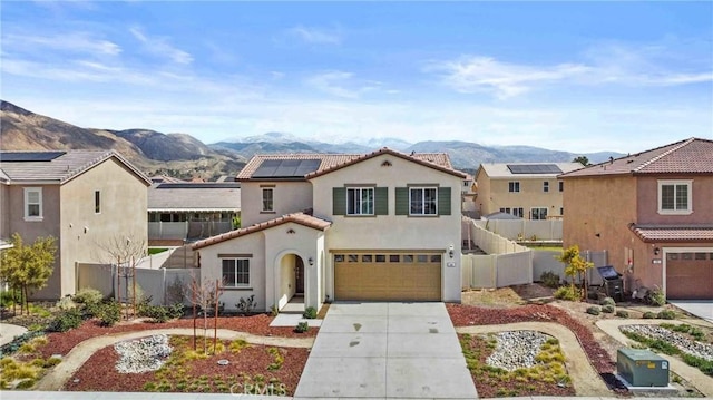 mediterranean / spanish home with fence, a mountain view, and concrete driveway