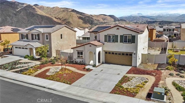 mediterranean / spanish house with a residential view, fence, concrete driveway, and stucco siding