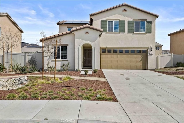 mediterranean / spanish-style home featuring roof mounted solar panels, fence, and stucco siding