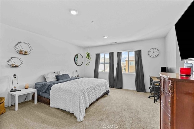 bedroom featuring visible vents and light colored carpet