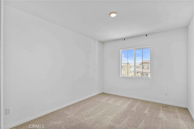 carpeted empty room with baseboards