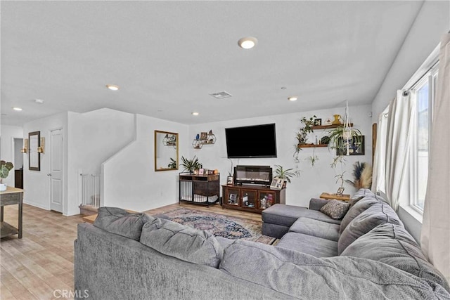 living area featuring light wood finished floors, visible vents, and recessed lighting