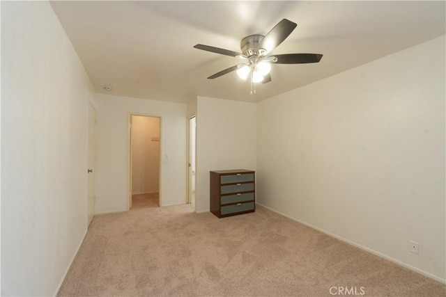 unfurnished bedroom featuring light colored carpet, ceiling fan, and baseboards