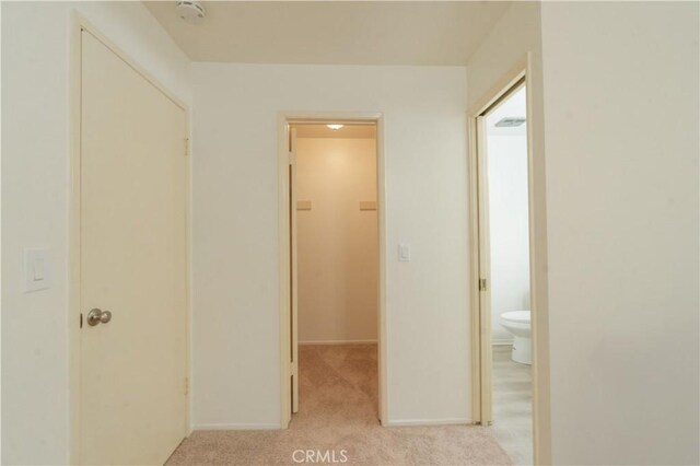 corridor with light carpet and baseboards