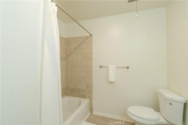 full bath featuring toilet, baseboards, and shower / bath combo with shower curtain