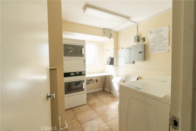 kitchen featuring light countertops, stacked washer / dryer, light tile patterned flooring, and electric panel