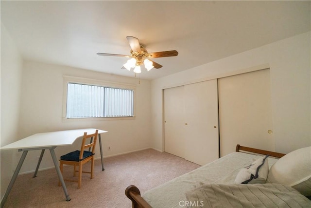 bedroom with baseboards, ceiling fan, a closet, and light colored carpet