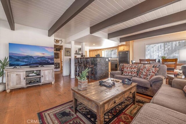 living area with beamed ceiling and hardwood / wood-style flooring