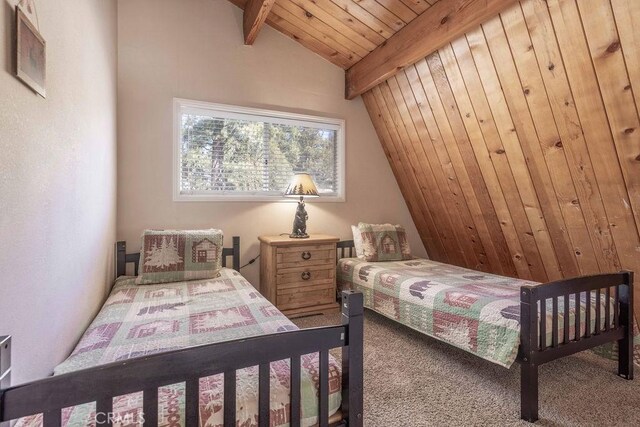 carpeted bedroom featuring vaulted ceiling with beams and wood ceiling