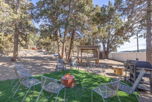 view of yard featuring a fenced backyard and a fire pit