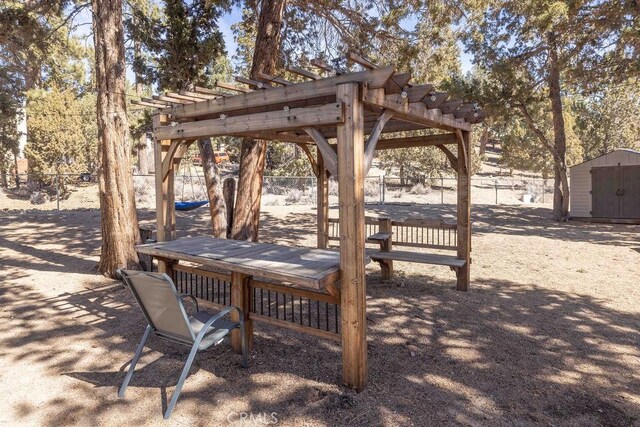 view of property's community featuring a storage unit, an outdoor structure, fence, and a pergola