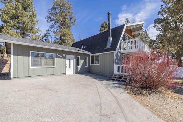 view of front of home with roof with shingles and a patio