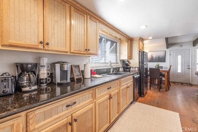 kitchen featuring light brown cabinets, light wood finished floors, and a sink