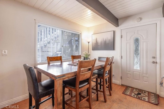 dining room with wooden ceiling, light wood finished floors, baseboards, and beamed ceiling