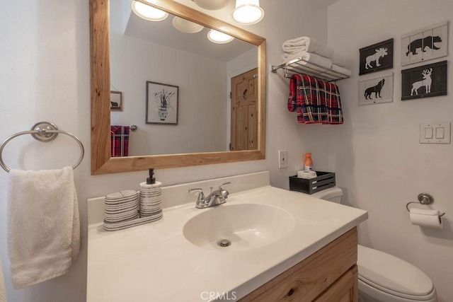 half bathroom with toilet and vanity