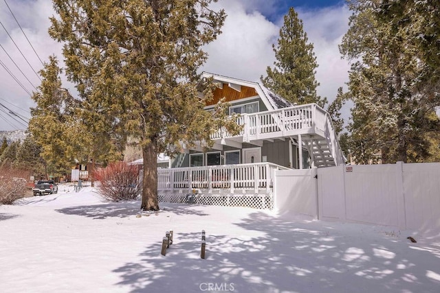 exterior space with a deck, a gate, fence, and a gambrel roof