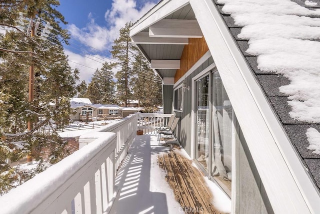 view of snow covered back of property