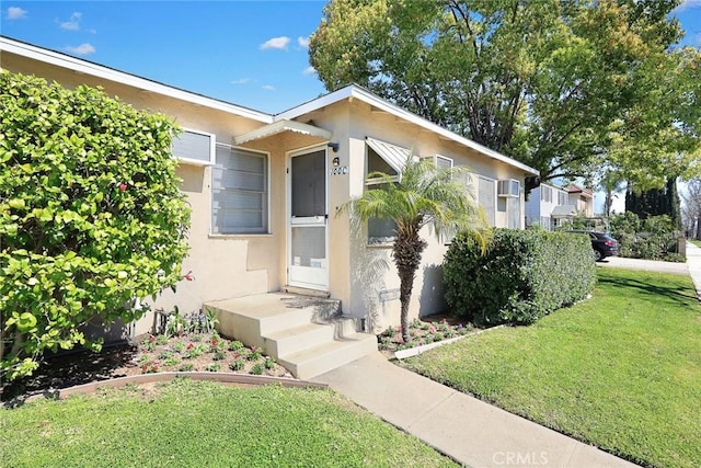 view of front of property with a front lawn and stucco siding